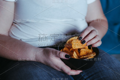 孤独悲伤的女人一边吃垃圾食品一边看电视