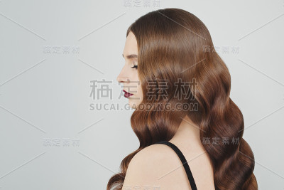 年轻的黑发模特有着完美的棕色长发在白色背景上