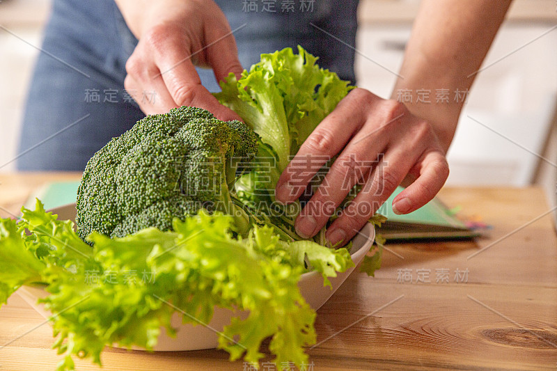 年轻漂亮的家庭主妇在白色的厨房里做饭