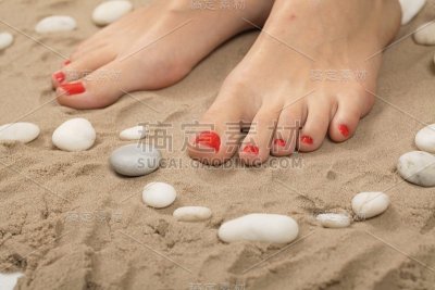 女性的脚在沙滩上