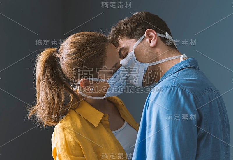 年轻夫妇戴着保护面罩亲吻