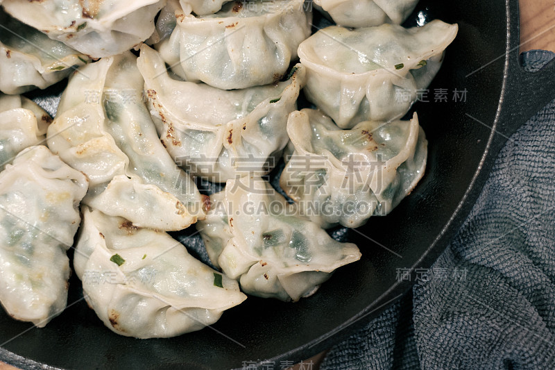 用铸铁煎锅煎自制饺子。