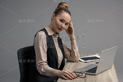 哈萨克女商人一边用笔记本电脑一边看相机