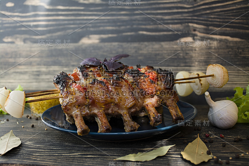 烤排骨与蔬菜和香料在木背景。侧视图。