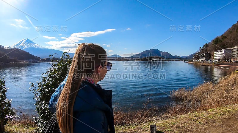 日本——一名女子站在川口町湖边，眺望富士山