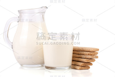 一壶牛奶和一杯牛奶，在白色背景上放一堆谷物脆饼