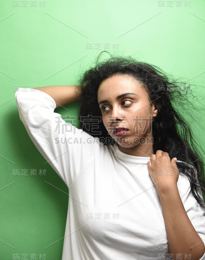 有着一头黑发的中东年轻女子。室内照片的奇妙女性模特在绿色的背景。