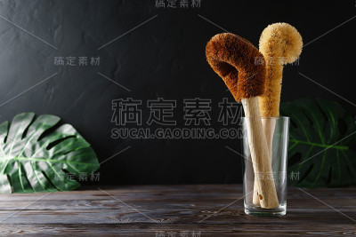两个用椰子毛做的刮刀和一个放在玻璃杯里的竹把手。