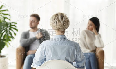 家庭顾问与坐在办公室里的夫妇交谈，后景