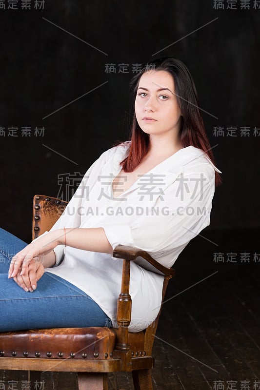 白皙皮肤，深色头发，红色发梢的白人妇女，穿着白色衬衫，背景为黑色