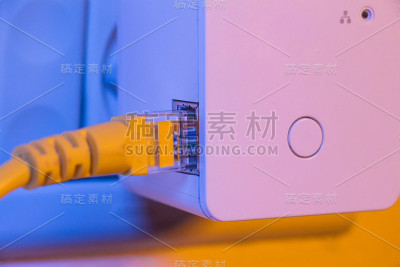 WiFi扩展器插在墙上的电源插座上，插着以太网线