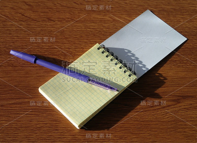 笔记本和钢笔放在木桌上
