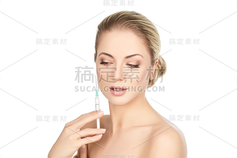 美丽的女孩拿着注射器孤立在白色