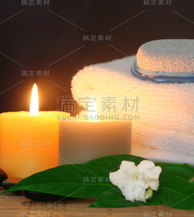 毛巾前有蜡烛和白色的丁香花