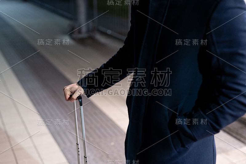一个在火车站拿着行李的白人商人