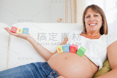 有魅力的孕妇在玩玩具