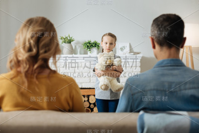 悲伤的孩子站在她父母面前