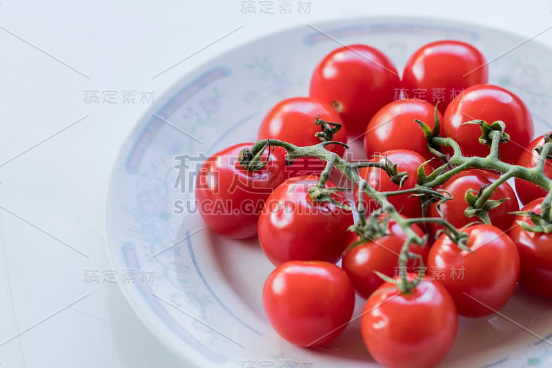 一些小可爱的西红柿在盘子里的高角度拍摄。特写照片。