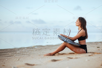 海滩上冲浪板上的漂亮女孩