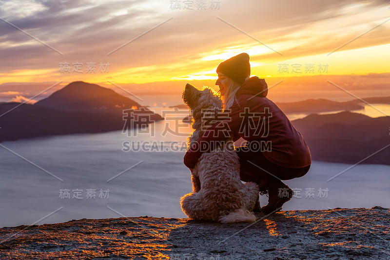 爱冒险的女孩带着狗在山顶徒步旅行