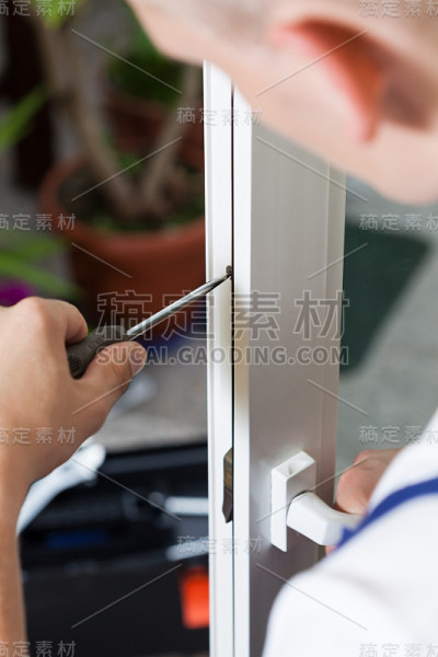 用螺丝刀修理窗户的勤杂工
