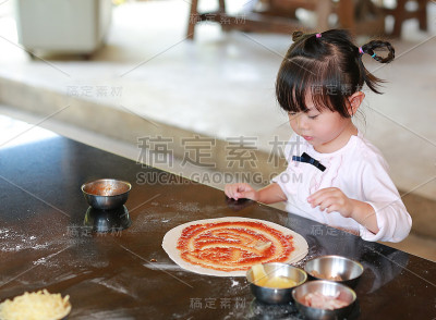 亚洲小女孩在做披萨。