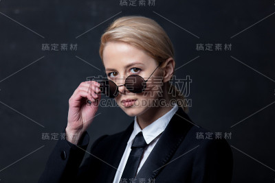 典型的女商人穿着黑色西装，戴着墨镜