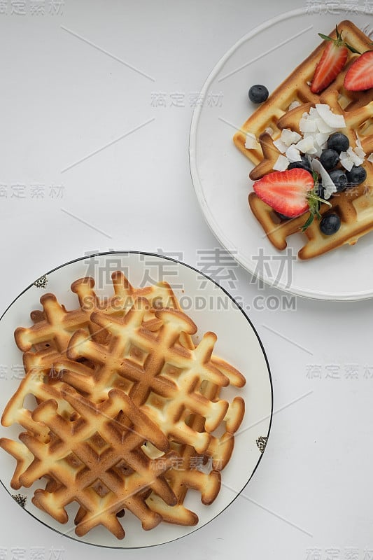 美丽的早餐:用浆果装饰的维也纳比利时华夫饼，一盘草莓和蓝莓