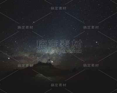 长时间曝光，夜空和银河与树木剪影的岩石形成