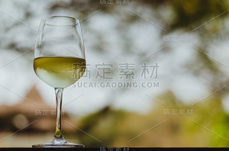 桌上放着一杯白葡萄酒。