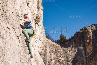 女人爬上一块石头。