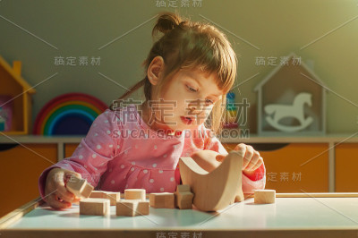美丽的小女孩玩木制玩具银河平衡器