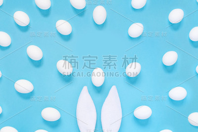 平铺构图的创意复活节兔子耳朵上的蓝色背景，文字空间