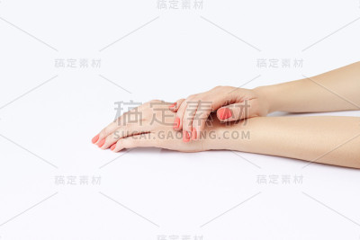 美丽的女性手与时尚的珊瑚亮美甲在白色的背景