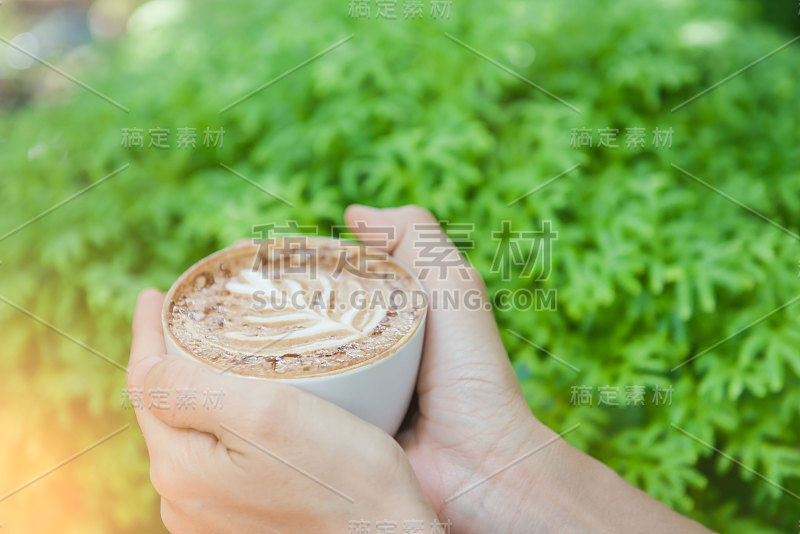 在咖啡店里，手里拿着一杯热咖啡的女人