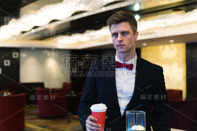 肖像的年轻商人在正式的西装享受一杯咖啡，自由的工作和责任。