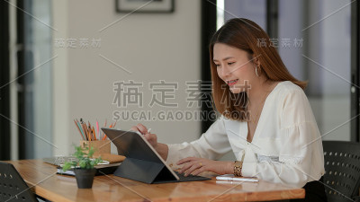 剪切镜头的自由职业者绘图在数字平板与文具在木制书桌上