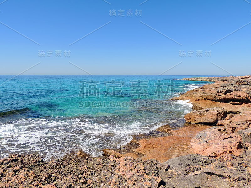 平静的蓝色大海和红岩海滩