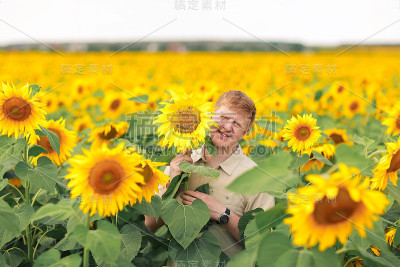 微笑的男人用手工的微笑捧着向日葵