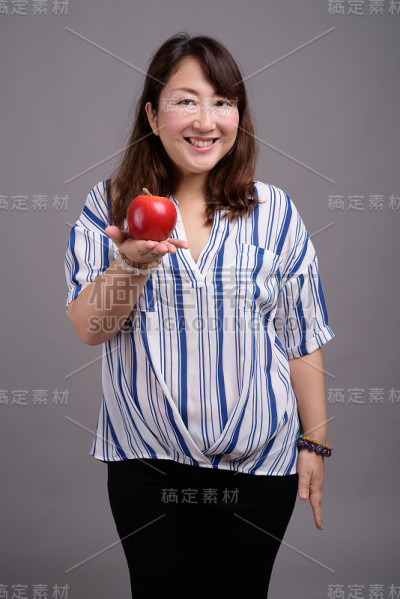工作室拍摄的成熟美丽的亚洲女商人在灰色的背景