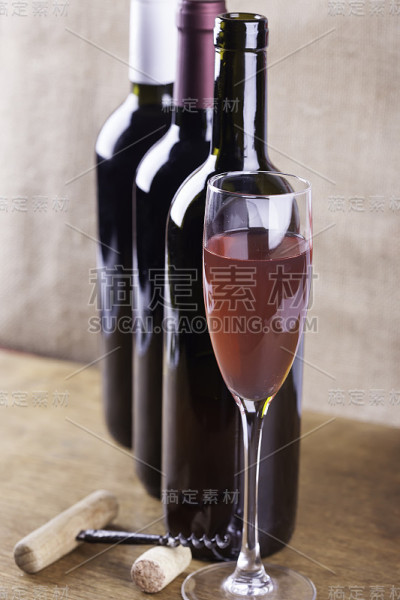 一杯玫瑰葡萄酒，开瓶器在背景上