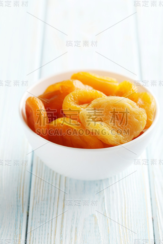 蓝色木桌上放着杏干