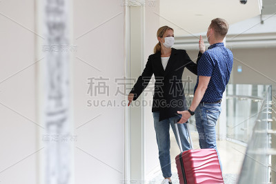 女人和男人互相给对方五个，拿着箱子站在门口