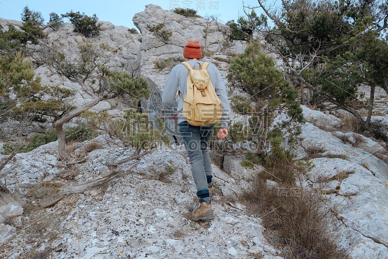 男人背包徒步旅行和红帽子在山区