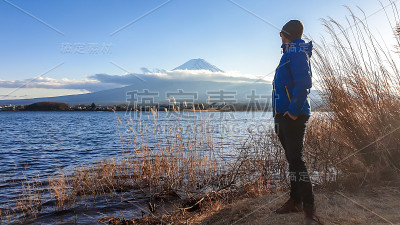 日本——一名男子站在川口湖边，眺望富士山