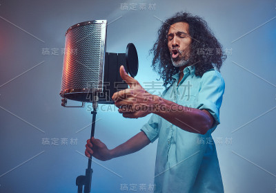 非洲声乐艺术家穿着一件蓝色衬衫情绪化地写歌在录音室。