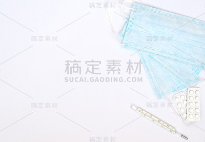蓝色医用口罩，体温计，白色背景上的白色药丸。季节性疾病。医学概念。平铺风格与复制空间，俯视图。