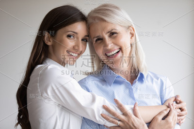 快乐的老妈妈和成年女儿拥抱的肖像