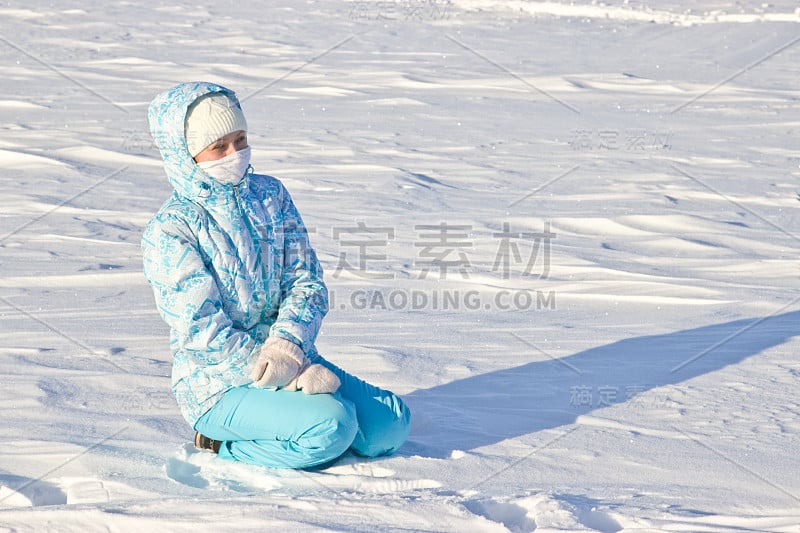 坐在雪地里的女人。明亮有霜的冬日。冰冻的河流伏尔加。