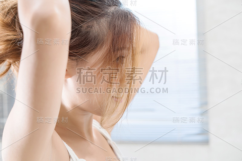 近距离的微笑女人化妆刷近脸和看镜子。亚洲美女